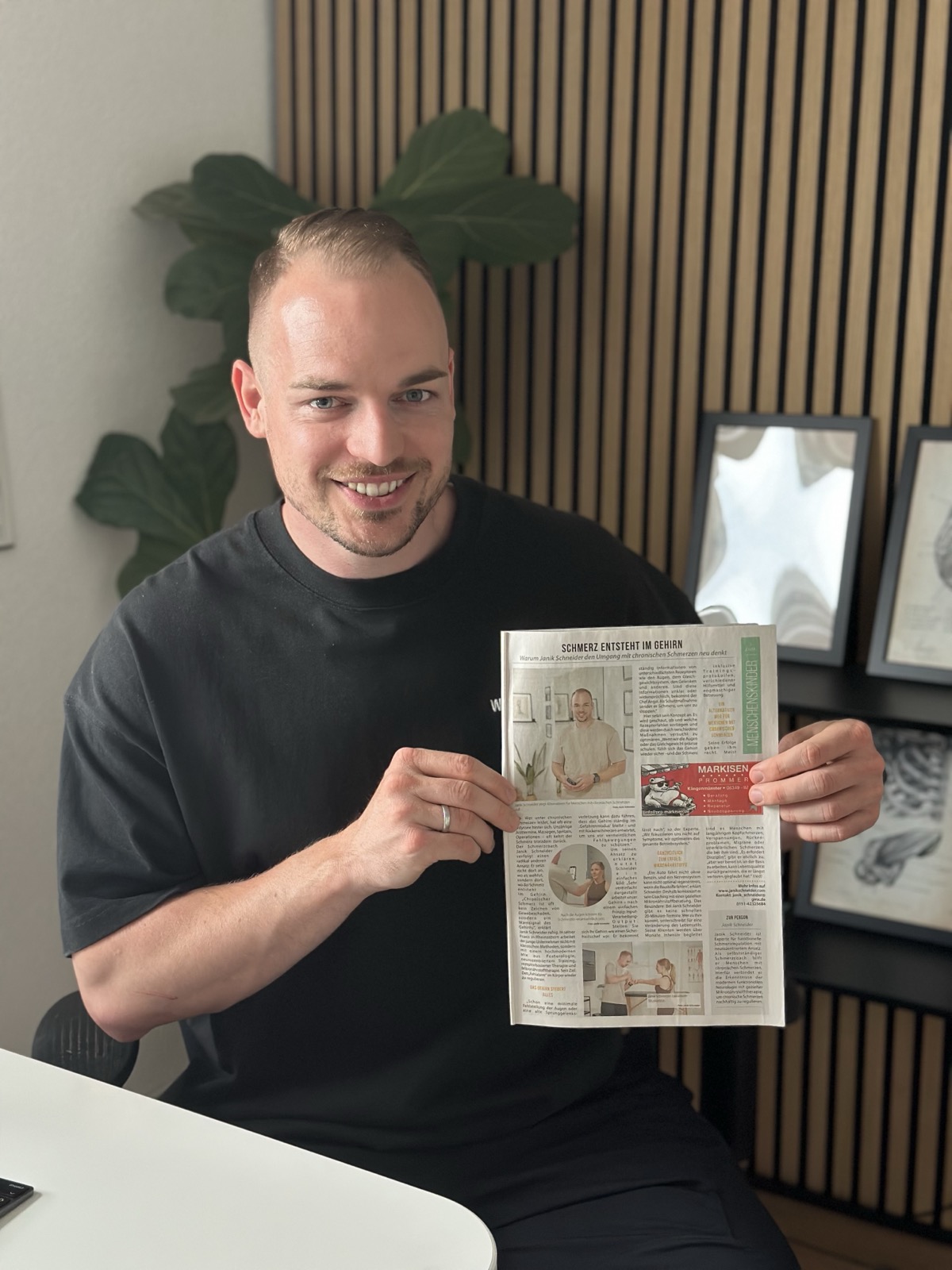 Janik Schneider hält den Pfalzecho-Artikel über sein Schmerzcoaching in der Hand